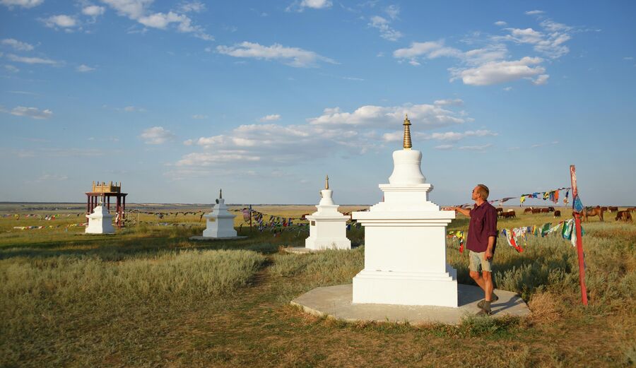 Мужчина совершает молитвенное обхождение восьми буддийских ступ, расположенных вокруг Одинокого Тополя