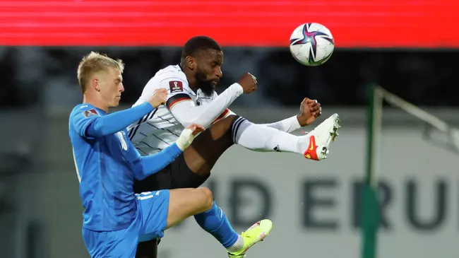 Germany's defender Antonio Ruediger (R) and Iceland's midfielder Albert Gudmundsson vie for the ball during the FIFA World Cup Qatar 2022 qualification Group J football match between Iceland and Germany in Reykjavik, on September 8, 2021. (Photo by Odd ANDERSEN / AFP)