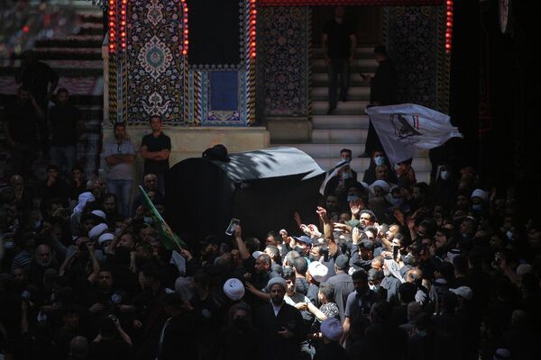 Скорбящие несут гроб Великого аятоллы Мухаммада Саида аль-Хакимав во время похоронной процессии в мавзолее Имама Хусейна в Кербеле, Ирак