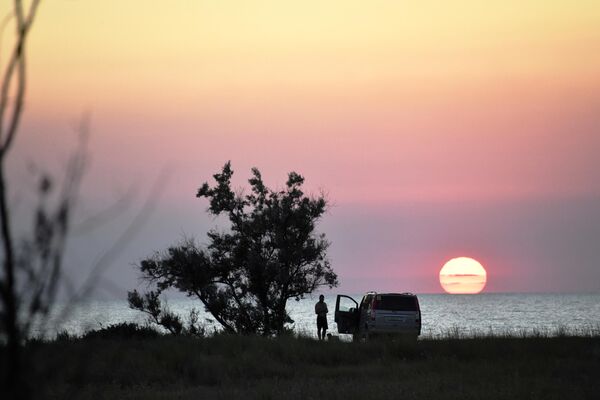 Туристы во время заката на берегу Генеральских пляжей Азовского моря в Республике Крым