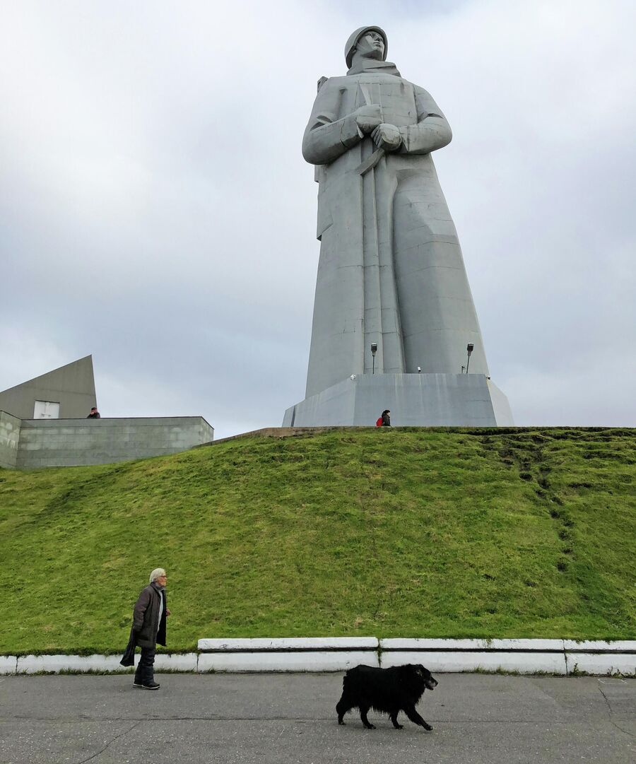 Женщина гуляет с собакой у подножия мемориала защитникам Советского Заполярья в Мурманске, на сопке Зеленый мыс