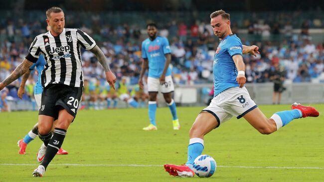 Napoli's Spanish midfielder Fabian Ruiz (R) shoots past Juventus' Italian forward Federico Bernardeschi (L) during the Serie A football match beetween Napoli and Juventus at The Maradona Stadium in Naples on September 11, 2021. (Photo by Carlo Hermann / AFP)