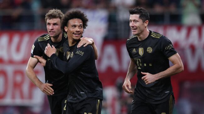 (L-R) Bayern Munich's German forward Thomas Mueller, Bayern Munich's German midfielder Leroy Sane and Bayern Munich's Polish forward Robert Lewandowski celebrate the 0-3 during the German first division Bundesliga football match between RB Leipzig and FC Bayern Munich in Leipzig, eastern Germany, on September 11, 2021. (Photo by Ronny HARTMANN / AFP) / DFL REGULATIONS PROHIBIT ANY USE OF PHOTOGRAPHS AS IMAGE SEQUENCES AND/OR QUASI-VIDEO