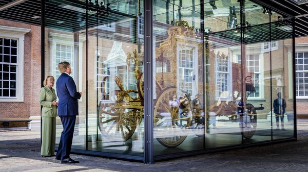 Король Виллем-Александр смотрит на Золотую Карету в музее Амстердама 
