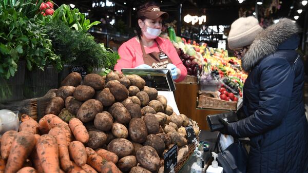 Женщина покупает овощи на ярмарке выходного дня в Москве