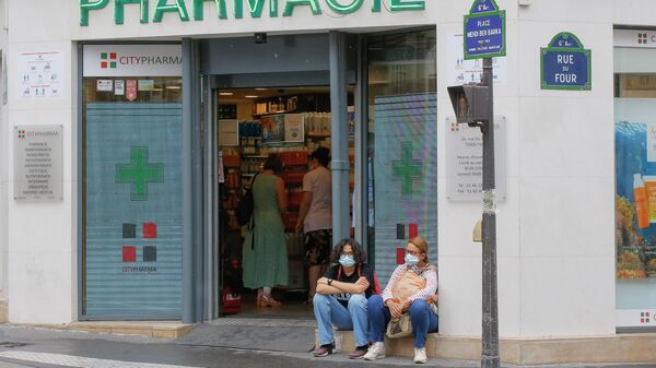 Женщины сидят у аптеки в Париже