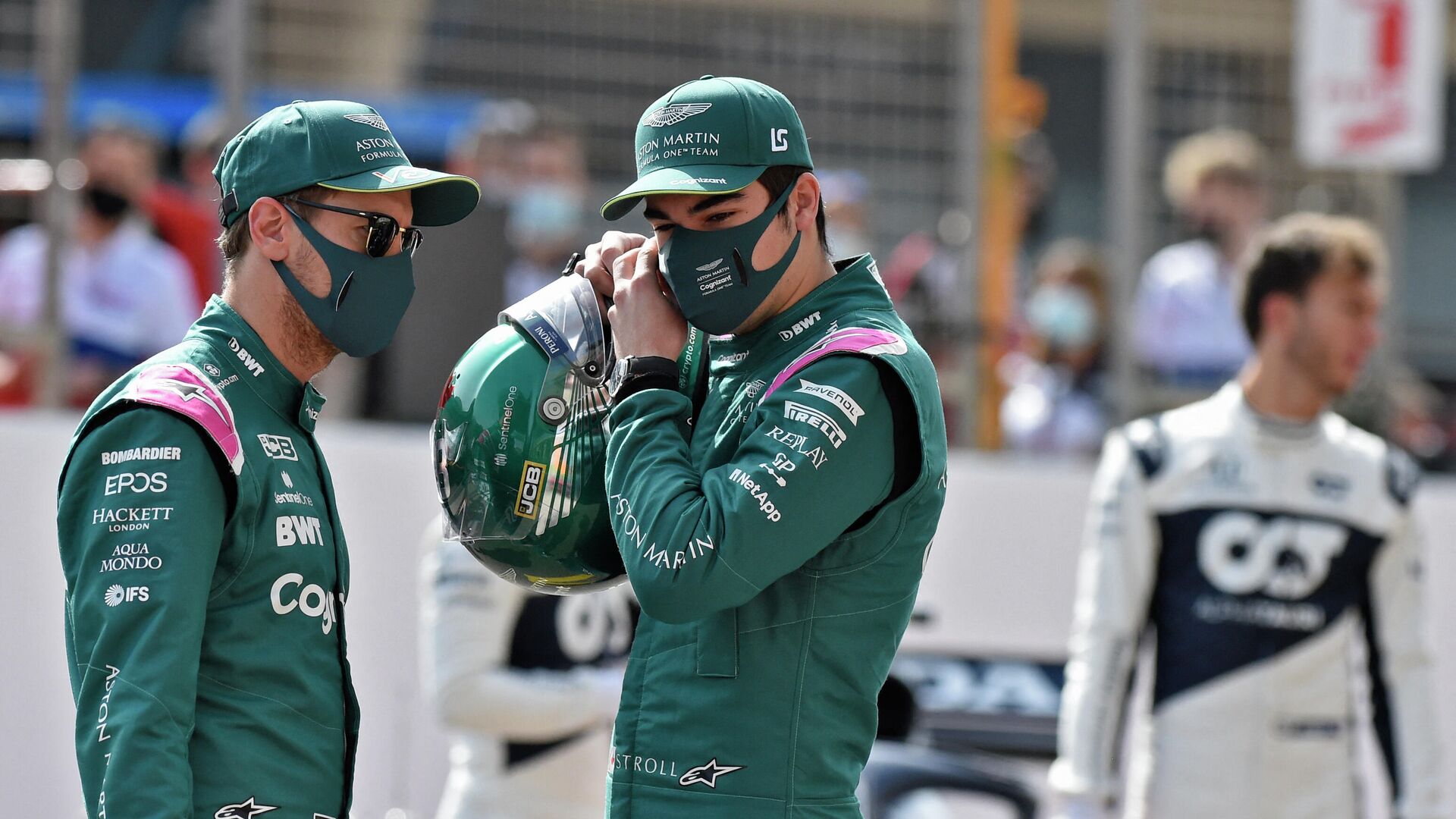 Aston Martin's German driver Sebastian Vettel (L) chats with Aston Martin's Canadian driver Lance Stroll (C) during the first day of the Formula One (F1) pre-season testing at the Bahrain International Circuit in the city of Sakhir on March 12, 2021. - Formula One teams take the wraps off their 2021 cars over three days of pre-season testing starting today at Bahrain's Sakhir International Circuit. Tickets for Formula One's season-opening Bahrain Grand Prix later this month will only be available to fans who have either been vaccinated or have recovered from coronavirus, organisers said. (Photo by Mazen MAHDI / AFP) - РИА Новости, 1920, 16.09.2021