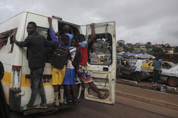 Местные жители едут в кузове грузовика в Конакри, Гвинея 