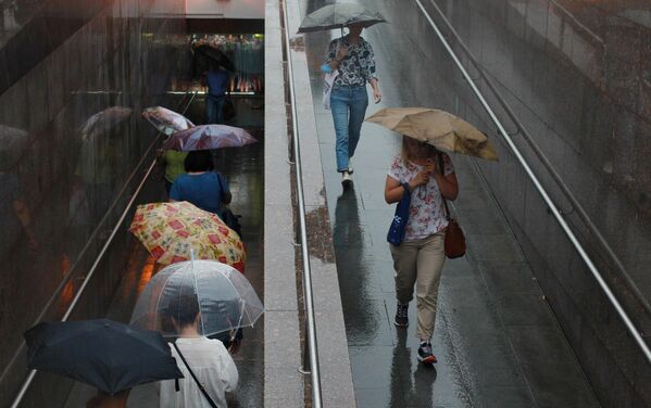 Люди во время дождя на одной из улиц в Москве