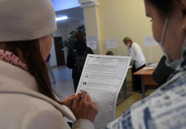 Девушки во время голосования на выборах в Госдуму на избирательном участке №49 в Москве