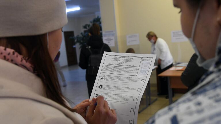 Девушки во время голосования на выборах в Госдуму на избирательном участке №49 в Москве