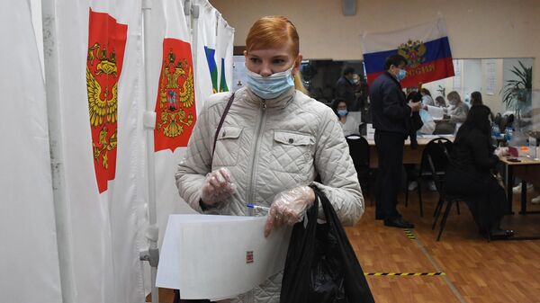 Женщина во время голосования на выборах в Госдуму во Владивостоке