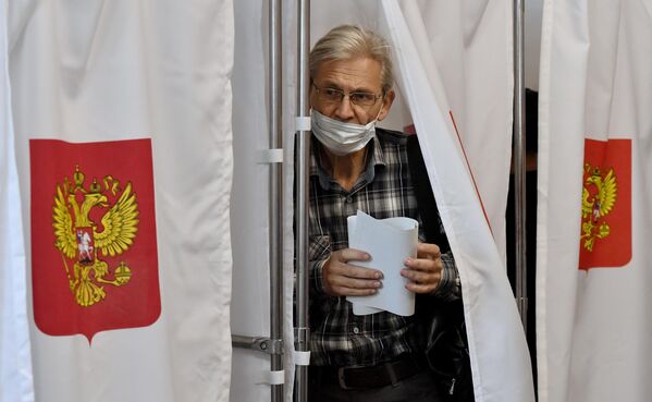 Мужчина голосует на избирательном участке в Симферополе