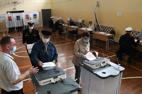 Люди голосуют на избирательном участке во Владивостоке