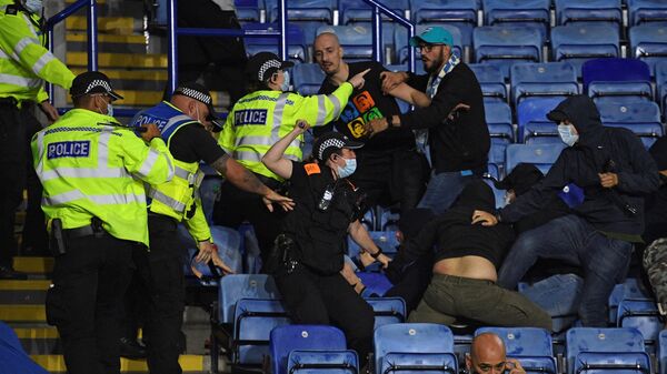 Police officers use batons as they hold back Napoli fans attempting to clash with Leicester fans after the final whistle during the UEFA Europa League Group C football match between Leicester City and Napoli at the King Power Stadium in Leicester, central England on September 16, 2021. - The match ended 2-2. (Photo by Oli SCARFF / AFP)