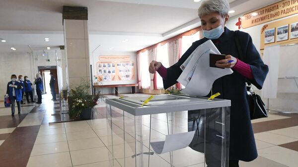 Женщина голосует на избирательном участке №199 на выборах депутатов Государственной Думы РФ в Республике Хакасия