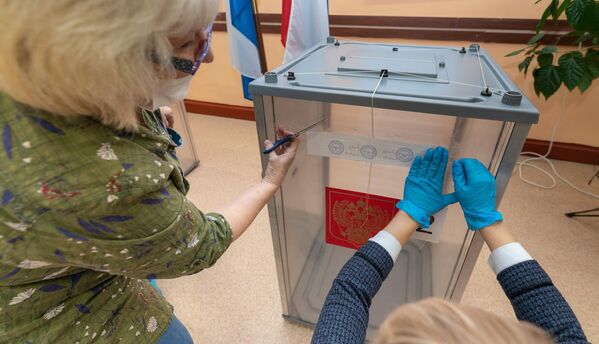 Сотрудники участковой избирательной комиссии №51 пломбируют стационарные урны для голосования перед открытием избирательного участка на выборах в Госдуму в Петропавловске-Камчатском