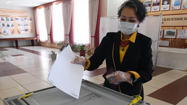 Женщина голосует на избирательном участке №199 на выборах депутатов Государственной Думы РФ в Республике Хакасия