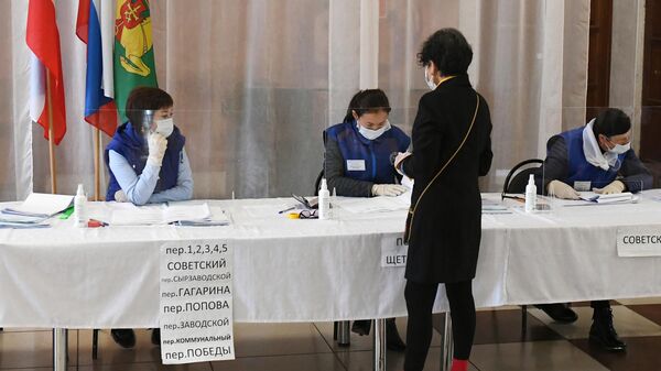 Избирательница получает бюллетень для голосования на избирательном участке в районном Центре культуры и досуга села Аскиз в Республике Хакасия