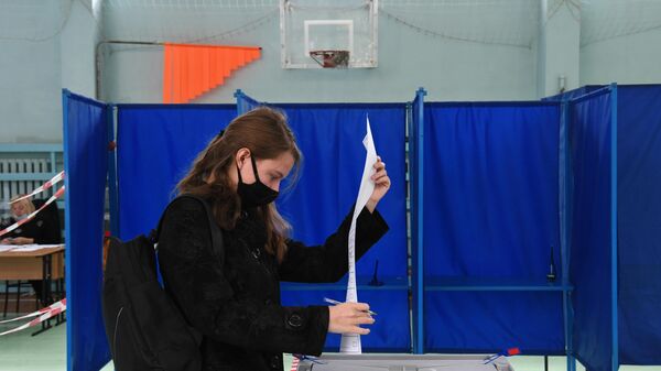 Девушка во время голосования на избирательном участке в Новосибирске