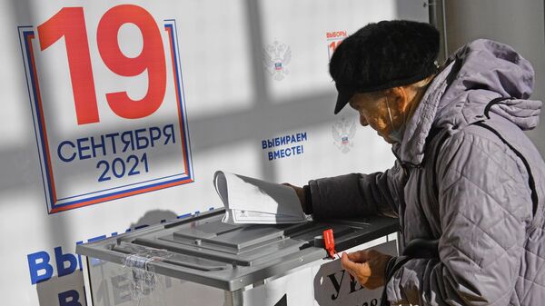 Пожилая женщина во время голосования на избирательном участке