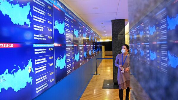 Экраны с номерами округов по голосованию в информационном центре Центральной избирательной комиссии РФ во время выборов в Госдуму 2021 года