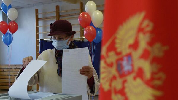 Женщина голосует на выборах депутатов Государственной Думы РФ