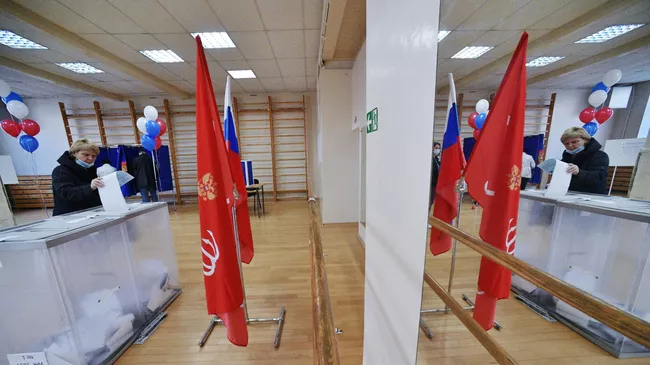 Избиратель голосует на участке в Санкт-Петербурге на выборах депутатов Государственной Думы РФ