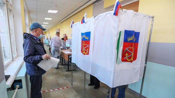 Мужчина голосует на выборах депутатов Государственной Думы РФ на одном из избирательных участков в Мурманске