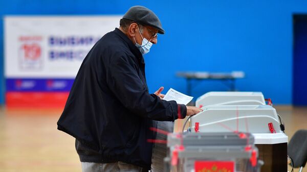 Мужчина голосует на выборах депутатов Государственной Думы РФ в Москве