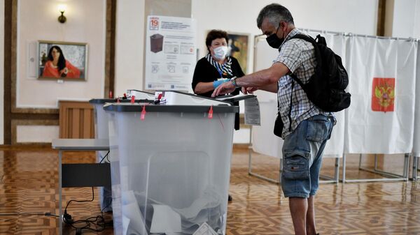 Избиратель на участке во время голосования на выборах депутатов Государственной Думы РФ в Севастополе