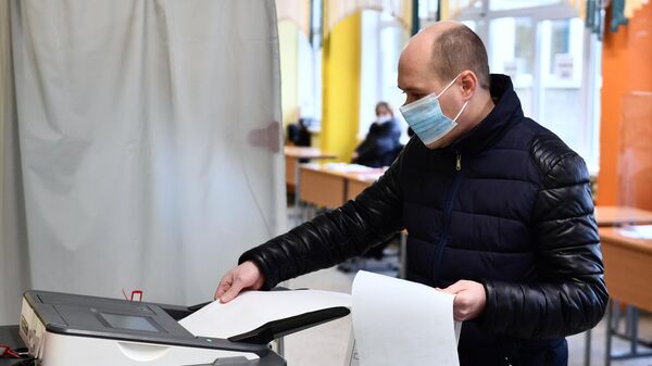 Мужчина голосует на выборах депутатов Государственной Думы РФ на избирательном участке в Екатеринбурге