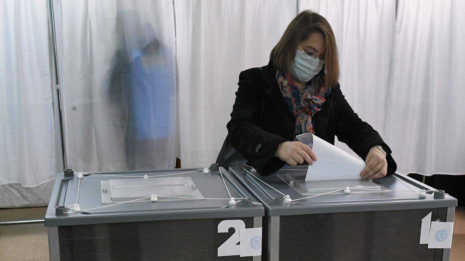 Избирательница опускает бюллетень в урну для голосования на избирательном участке в Красноярском крае - РИА Новости, 1920, 20.09.2021