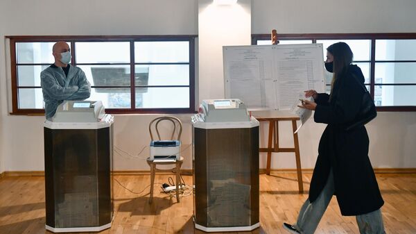 Девушка во время голосования на выборах депутатов Государственной Думы на избирательном участке № 60 в Москве