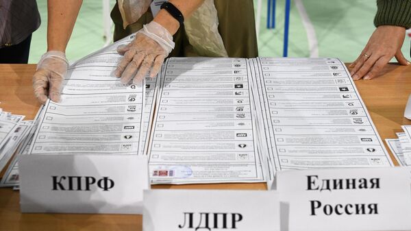 Сортировка бюллетеней во время подсчета голосов после закрытия избирательного участка в Новосибирске