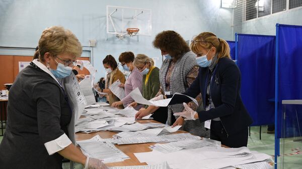Сортировка бюллетеней во время подсчета голосов после закрытия избирательного участка в Новосибирске