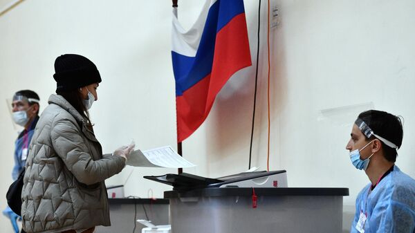Женщина голосует на выборах депутатов Государственной Думы РФ на избирательном участке № 1331 в Екатеринбурге