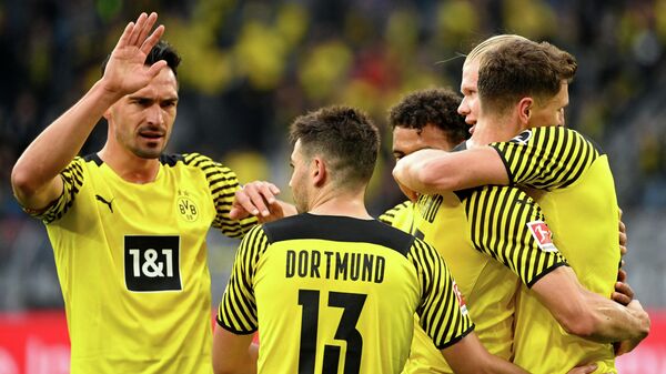 Dortmund's Norwegian forward Erling Braut Haaland (R) celebrates with Dortmund's German defender Mats Hummels (L), Dortmund's Portuguese defender Raphael Guerreiro (2nd L) and other teammates after scoring the 2-0 during the German first division Bundesliga football match Borussia Dortmund vs FC Union Berlin on September 19, 2021 in Dortmund, western Germany. (Photo by Ina Fassbender / AFP) / DFL REGULATIONS PROHIBIT ANY USE OF PHOTOGRAPHS AS IMAGE SEQUENCES AND/OR QUASI-VIDEO