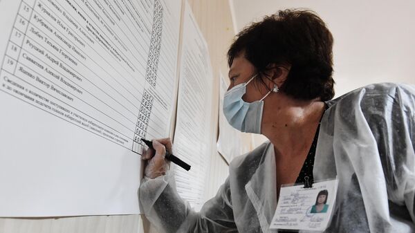 Сотрудница избирательной комиссии подсчитывает бюллетени после закрытия избирательного участка