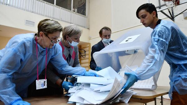 Члены избирательной комиссии подсчитывают бюллетени после закрытия избирательного участка