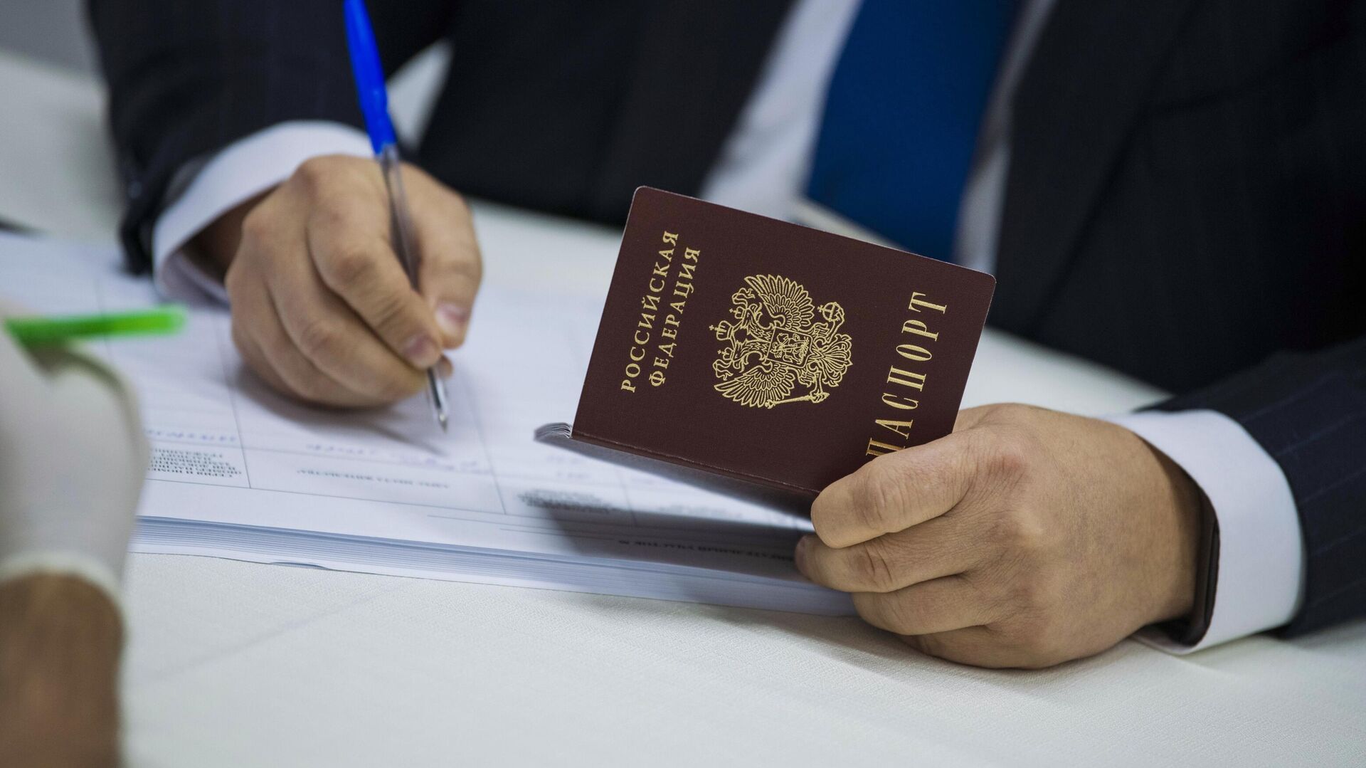 Мужчина с паспортом гражданина России заполняет документ - РИА Новости, 1920, 08.05.2022