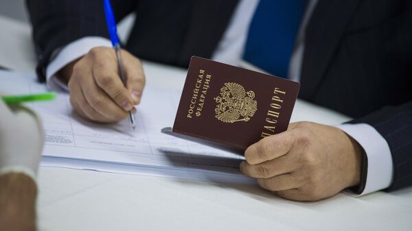 Мужчина с паспортом гражданина РФ заполняет документ