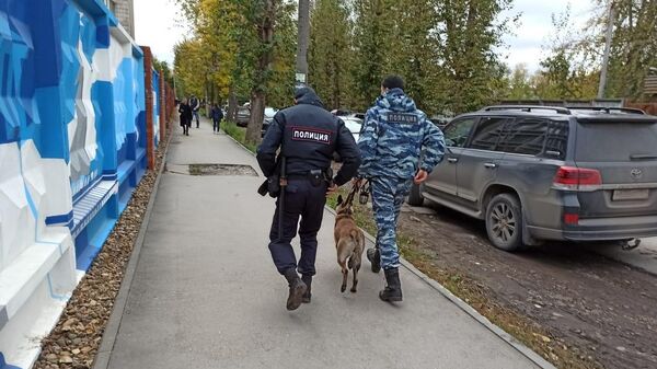 Сотрудники полиции со служебной собакой на улице Перми 
