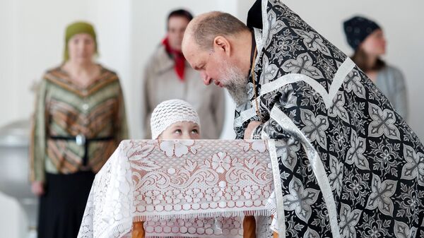 Священнослужитель исповедуют верующих в день Великой субботы в Князе-Владимирском храме города Иркутска.