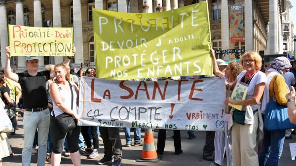 Участники во время протестов против COVID-ограничений в Париже
