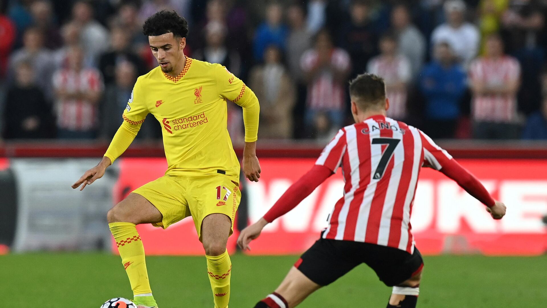 Liverpool's English midfielder Curtis Jones (L) vies with Brentford's Spanish striker Sergi Canos during the English Premier League football match between Brentford and Liverpool at Brentford Community Stadium in London on September 25, 2021. (Photo by Glyn KIRK / AFP) / RESTRICTED TO EDITORIAL USE. No use with unauthorized audio, video, data, fixture lists, club/league logos or 'live' services. Online in-match use limited to 120 images. An additional 40 images may be used in extra time. No video emulation. Social media in-match use limited to 120 images. An additional 40 images may be used in extra time. No use in betting publications, games or single club/league/player publications. /  - РИА Новости, 1920, 25.09.2021