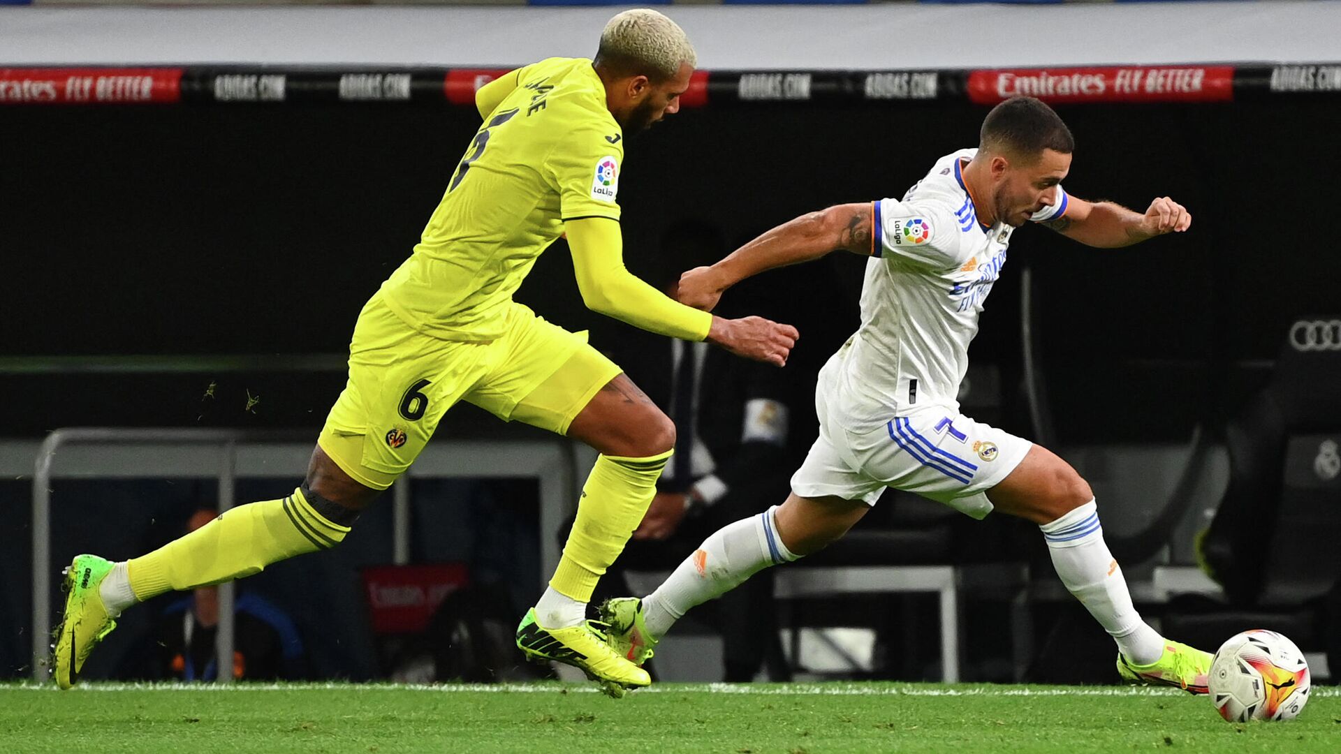 Villarreal's French midfielder Etienne Capoue (L) challenges Real Madrid's Belgian forward Eden Hazard during the Spanish League football match between Real Madrid and Villarreal CF at the Santiago Bernabeu stadium in Madrid on September 25, 2021. (Photo by GABRIEL BOUYS / AFP) - РИА Новости, 1920, 26.09.2021