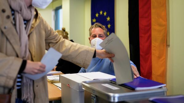 Женщина голосует на одном из избирательных участков в Берлине во время парламентских выборов в Германии