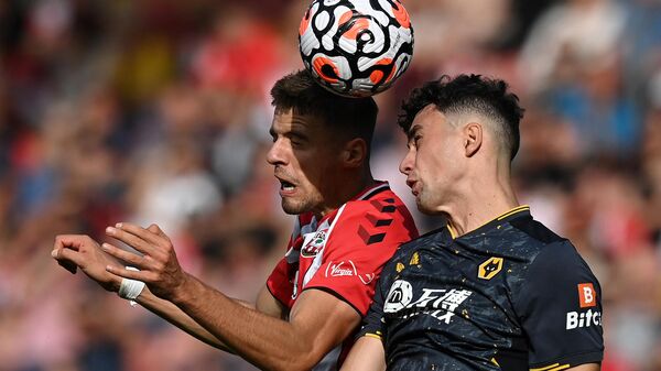 Southampton's Polish defender Jan Bednarek (L) vies to header the ball with Wolverhampton Wanderers' English defender Max Kilman during the English Premier League football match between Southampton and Wolverhampton Wanderers at St Mary's Stadium in Southampton, southern England on September 26, 2021. (Photo by Glyn KIRK / AFP) / RESTRICTED TO EDITORIAL USE. No use with unauthorized audio, video, data, fixture lists, club/league logos or 'live' services. Online in-match use limited to 120 images. An additional 40 images may be used in extra time. No video emulation. Social media in-match use limited to 120 images. An additional 40 images may be used in extra time. No use in betting publications, games or single club/league/player publications. / 