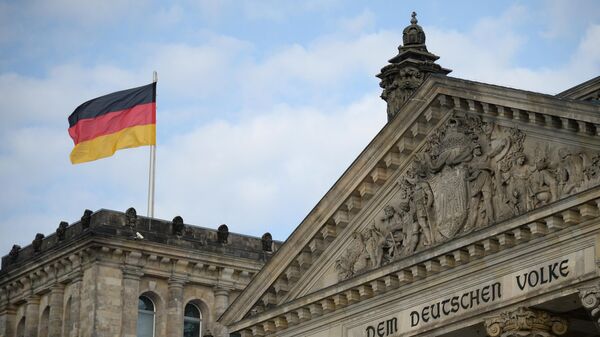 Национальный флаг Федеративной Республики Германии над зданием Будестага в Берлине